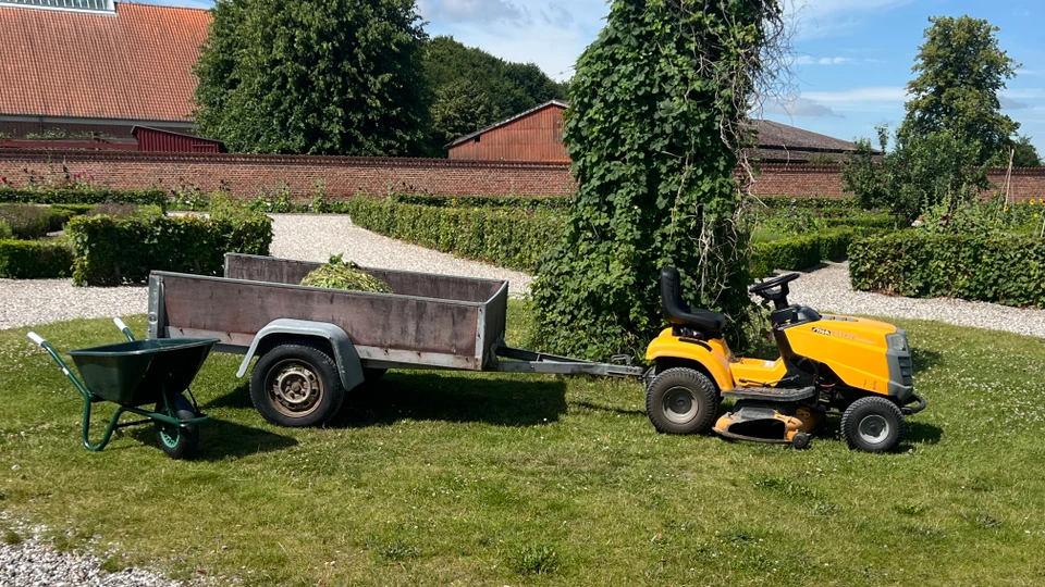 Billede af en gul havetraktor med trailer efter